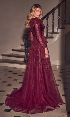 A woman wears a Ladivine CM394 long formal dress with a dark red velvet bodice, long sleeves, and a full A-line glitter tulle skirt adorned with floral embellishments.