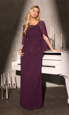 A woman wearing the Ladivine CR884 long formal dress in eggplant with beaded shoulder detail stands beside a white piano, surrounded by tall and short white candles.
