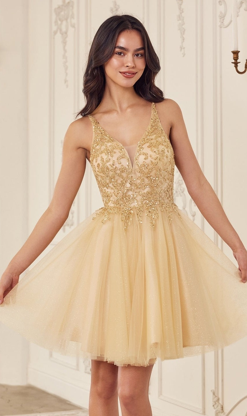 A woman in the Lace-Up Short A-Line Homecoming Dress CY022, featuring a sleeveless gold design with intricate embroidery, stands indoors against an ornate white wall, smiling with her arms slightly outstretched.