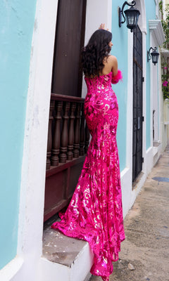 A woman in the Strapless Sequin-Print Prom Dress with Gloves D1269 stands on a narrow ledge outside a pastel blue building, facing away from the camera.