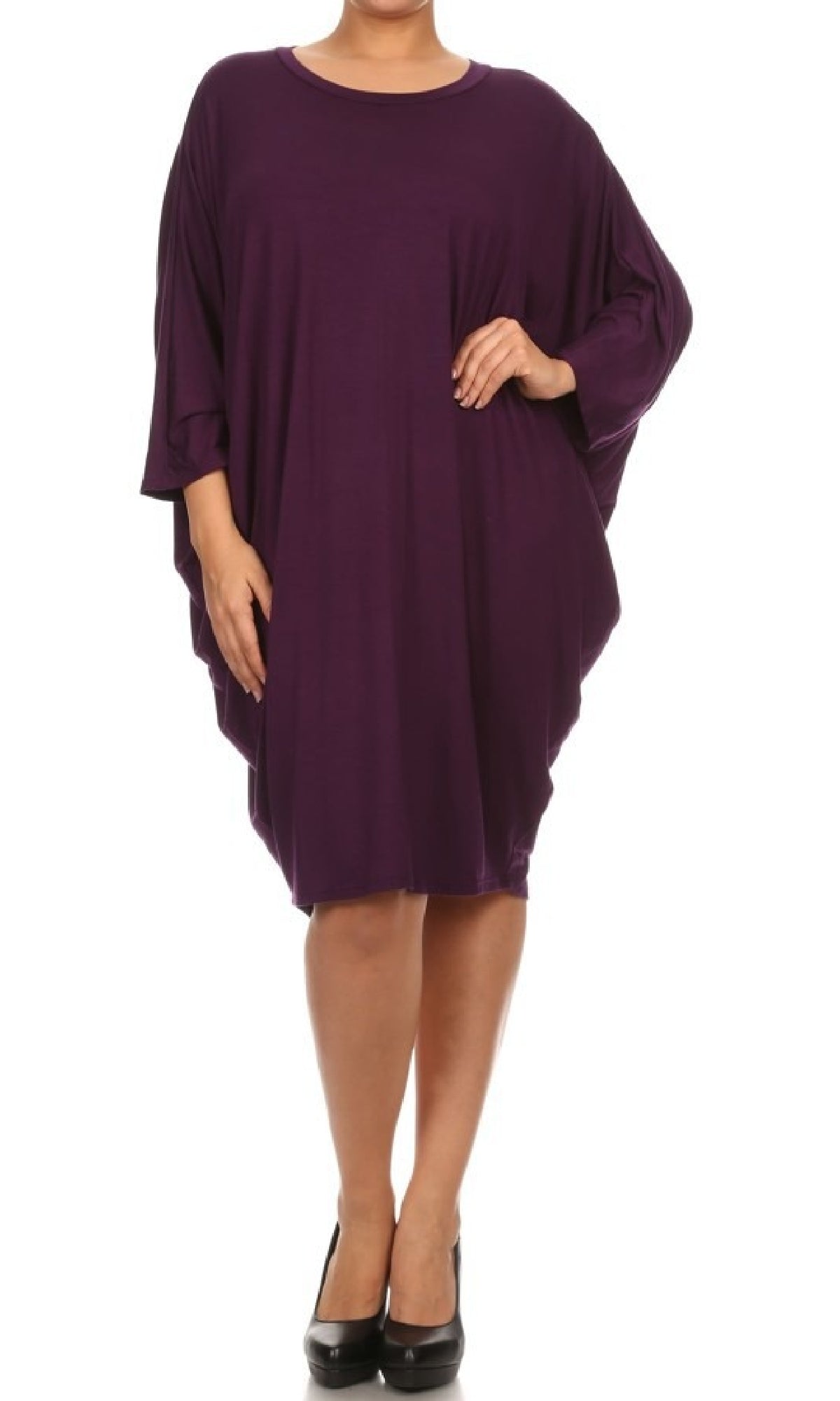 A person wears the Short Casual Plus Size Dress with Dolman Sleeves—a loose-fitting, knee-length, purple dress—paired with black heels, standing against a white background.