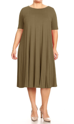 A person wears the Plus-Size Jersey Knit Oversized A-Line Casual Dress in olive green, featuring short sleeves and knee length, paired with beige heels, standing against a white background.