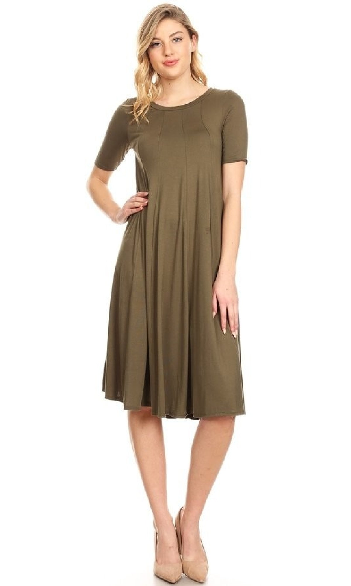 A woman wears the Short Sleeve Casual Oversized Jersey Knit Dress in olive green with short sleeves and a flared skirt, paired with nude heels, against a plain white background.
