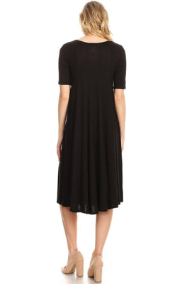 A woman faces away, wearing the Short Sleeve Casual Oversized Jersey Knit Dress in black with short sleeves and beige heeled shoes, set against a white background.
