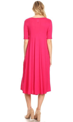 A woman stands facing away against a white background, wearing the Short Sleeve Casual Oversized Jersey Knit Dress in bright pink with short sleeves and tan block-heeled shoes.