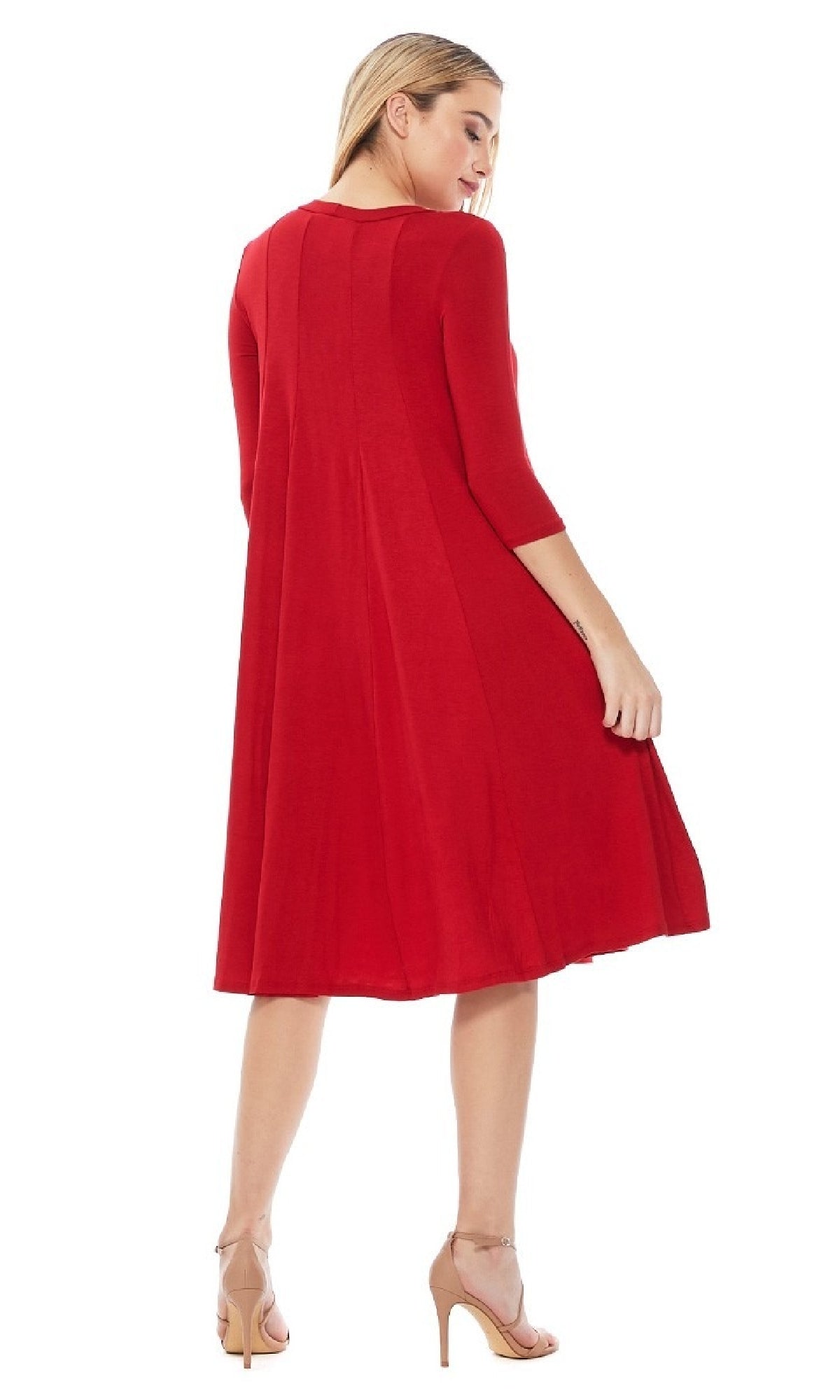 A woman models the Knee-Length Casual Party Dress with long sleeves and nude heels, standing with her back slightly turned.