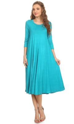 A woman models a turquoise Knee-Length Casual Party Dress with long sleeves and a flared skirt, paired with silver high-heeled sandals, standing against a white background.