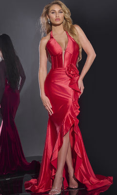 A woman stands against a dark background wearing the Jovani D5306 long prom dress—form-fitting in deep red with a corset bodice, plunging neckline, ruffle accents, and a high slit.
