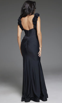 A woman stands with her back to the camera in the Jovani D5810 long prom dress, featuring a form-fitting black design with shoulder-strap rosette details and a dramatic mermaid silhouette.