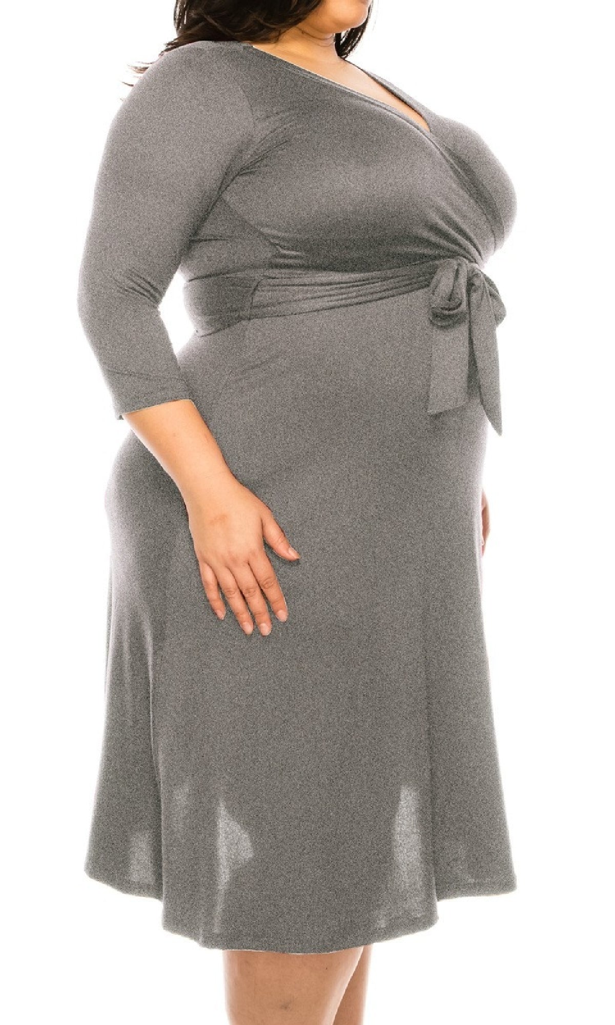 A person wears the Faux-Wrap Plus-Size Casual Dress with Sleeves in gray, featuring long sleeves, a knee-length hem, and a waist tie, standing against a white background.