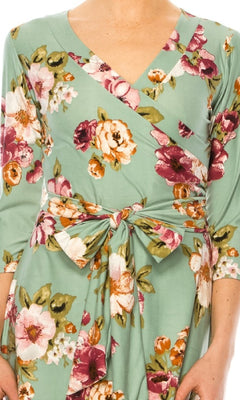 Someone is wearing a Sage Green Floral Print Faux-Wrap Casual Dress with a V-neckline, three-quarter sleeves, and a chic front tie detail.