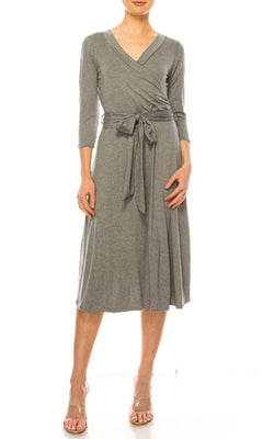 A person models the Faux-Wrap Casual Short Dress with Sleeves—a grey, knee-length dress featuring a v-neckline and belt—paired with open-toe heels against a white background.