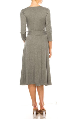 A woman faces away in the Faux-Wrap Casual Short Dress with Sleeves, a gray, knee-length style featuring three-quarter sleeves, a belt, and clear heeled sandals.