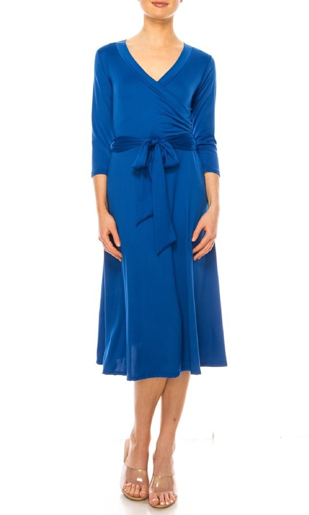 A woman models the Faux-Wrap Casual Short Dress with Sleeves—a knee-length, blue dress featuring long sleeves, a waist tie, and v-neckline—styled with beige open-toe heels against a white background.