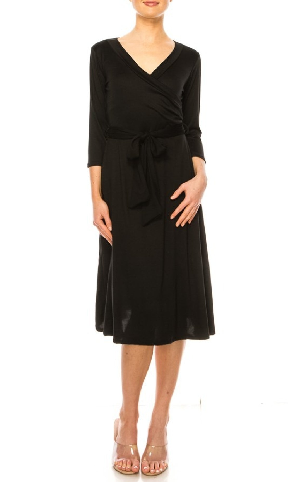 A woman models the Faux-Wrap Casual Short Dress with Sleeves—knee-length, black, v-neck, 3/4 sleeves, waist tie—paired with open-toe heels against a white background.