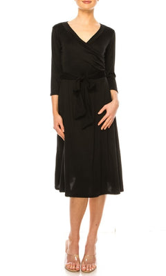 A woman models the Faux-Wrap Casual Short Dress with Sleeves—knee-length, black, v-neck, 3/4 sleeves, waist tie—paired with open-toe heels against a white background.