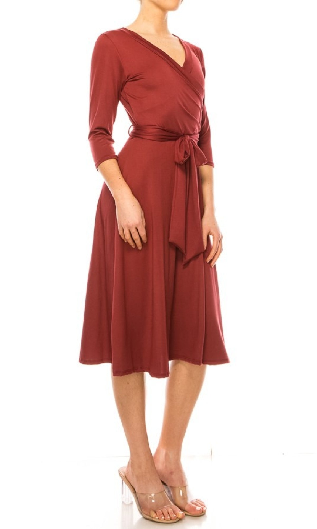 Woman wearing the Faux-Wrap Casual Short Dress with Sleeves in rust, featuring a v-neckline and waist tie, paired with clear open-toe shoes against a white background.