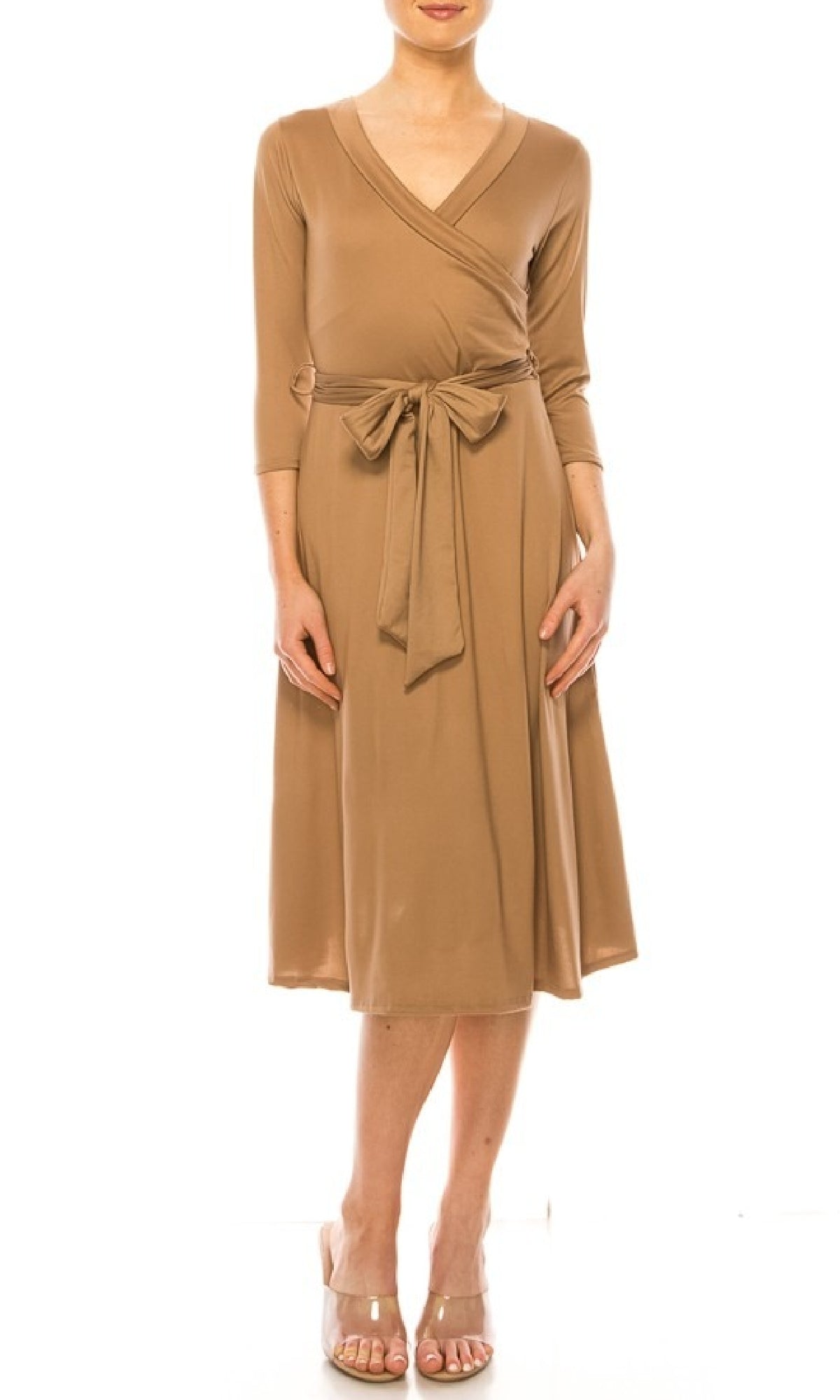 A woman models the Faux-Wrap Casual Short Dress with Sleeves—knee-length, tan, with a v-neckline, three-quarter sleeves, and waist tie—paired with nude heels against a white background.