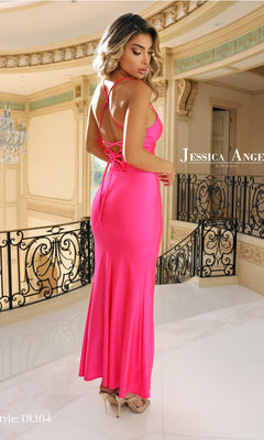 A woman wearing the Jessica Angel DL104 Lace-Up Long Prom Dress in bright pink stands indoors on a marble floor before ornate railings and beige walls.