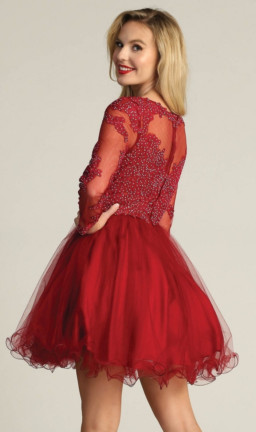 A woman in the Beaded Long Sleeve Short Homecoming Dress DM4003, featuring a red knee-length tulle skirt, long sheer sleeves, and a beaded bodice, stands smiling and looking over her shoulder.