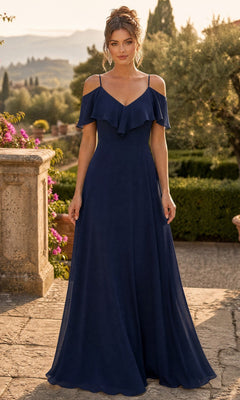 A woman wearing the navy Long Formal Dress: Chicas DM4004, featuring a floor-length chiffon silhouette and off-shoulder design, stands outdoors on a stone terrace with greenery and trees in the background.
