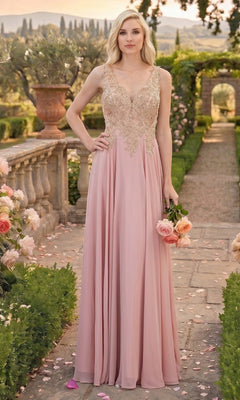 A woman in the Chicas DM4006 long formal dress in dusty rose, featuring a sleeveless design and an embroidered bodice, stands on a garden path holding roses, surrounded by flowers and greenery under soft daylight.