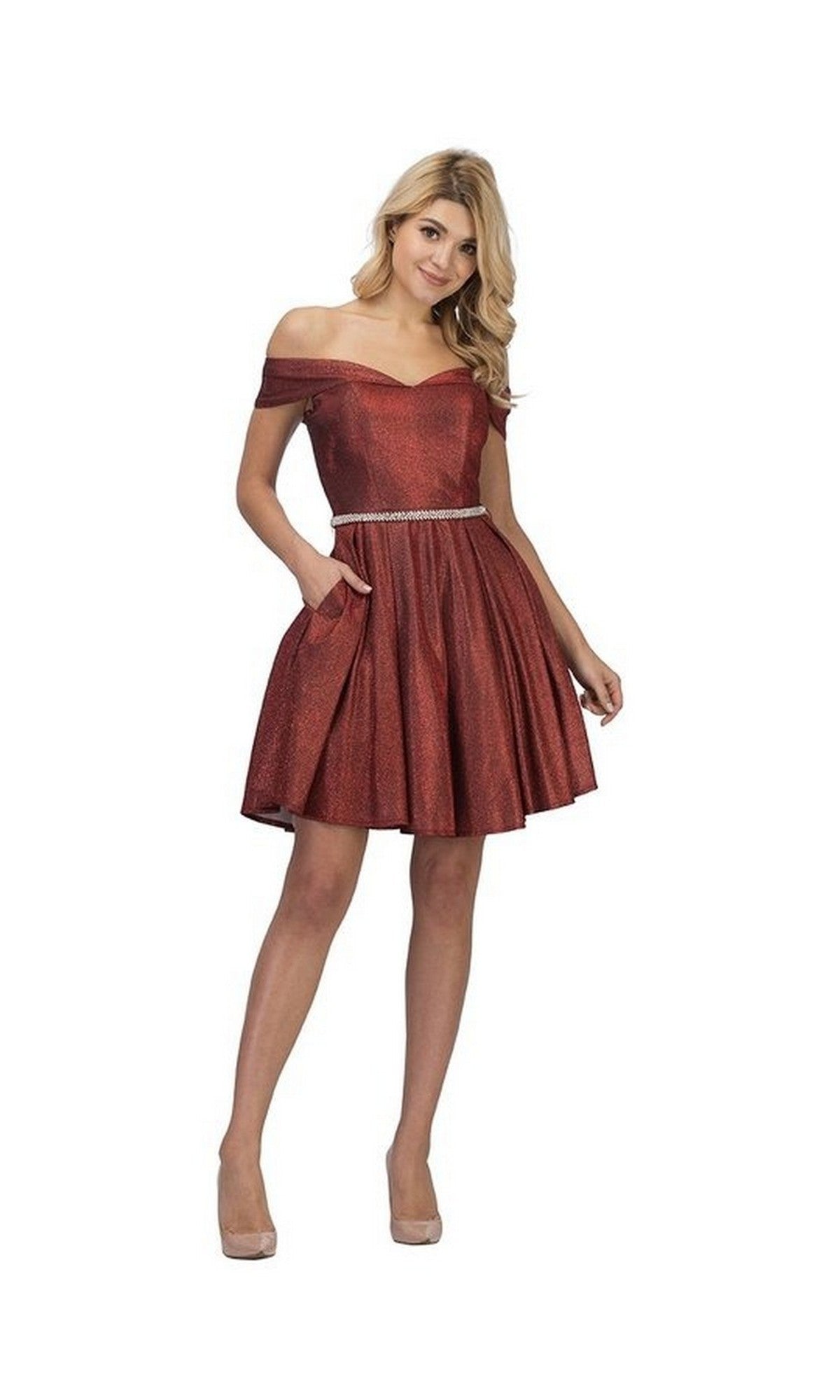 A woman stands in neutral heels against a white background, wearing the Short Homecoming Dress: Chicas DM4014 in a shimmery burgundy hue. The dress features an off-the-shoulder neckline, fitted bodice, A-line flared skirt, and is accented with a silver belt.