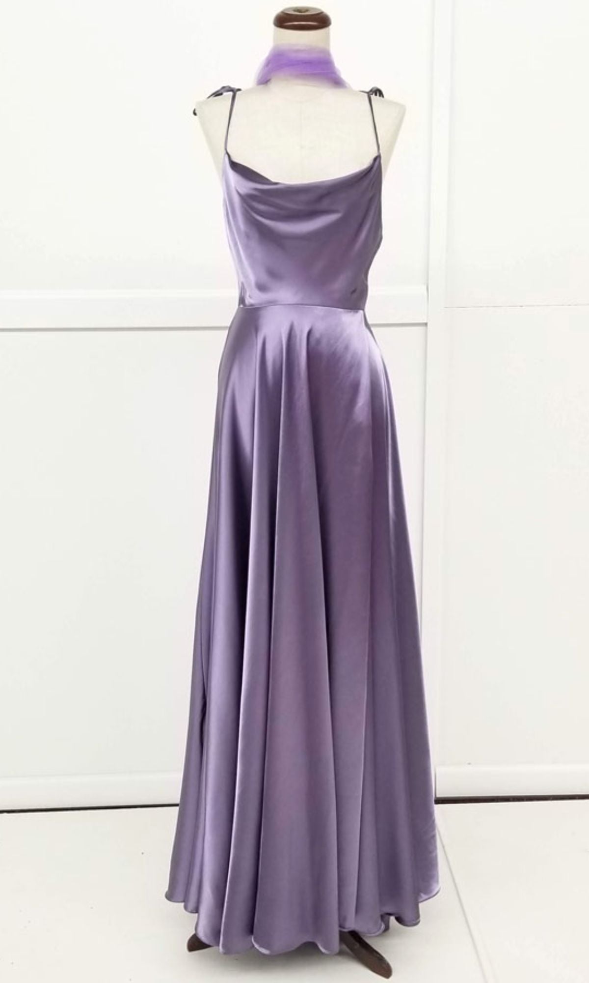 The Chicas DM4018 Shoulder-Tie Long A-Line Prom Dress, featuring a floor-length lavender satin design with a cowl neckline and matching scarf, is elegantly displayed on a dress form.