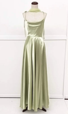 The Chicas DM4018 is a sleeveless, light green satin prom dress with shoulder ties, cowl neckline, fitted bodice, and a long flowing A-line skirt, displayed on a dress form against a plain background.