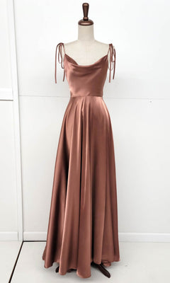 The Shoulder-Tie Long A-Line Prom Dress (Chicas DM4018), a floor-length copper satin gown with a cowl neckline and tied spaghetti straps, is displayed on a dress form against a white background.