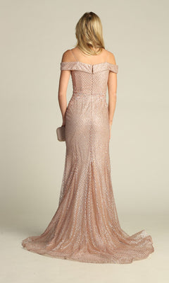 A person stands facing away, holding a small clutch and wearing the Off-the-Shoulder Long Prom Dress: Chicas DM4024—a floor-length, blush pink mermaid gown with a subtle pattern.