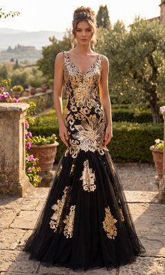 A woman stands outdoors on a stone pathway amidst lush greenery and blooming flowers, wearing the Long Sequin Mermaid Prom Dress (Chicas DR7009) in Black/Gold.