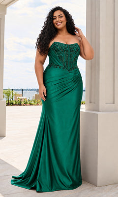 A smiling woman wears the Long Plus-Size Prom Dress: Faviana 11606E in dark emerald, a satin gown featuring a strapless, corset-style bodice with beaded detailing.
