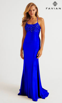A woman in a Faviana E11201 strappy open-back long prom dress with a beaded bodice stands against a plain background, the "FAVIAN" logo in the corner.