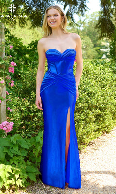 A woman poses outdoors among greenery and pink flowers in the Faviana E11422 long prom dress, featuring a strapless corset bodice, sweetheart neckline, bright blue fabric, and a thigh-high slit.
