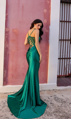 A woman in the Lace-Up Corset-Bodice Long Satin Prom Dress E1292 stands on a sidewalk facing a pink wall, glancing over her shoulder at the camera.