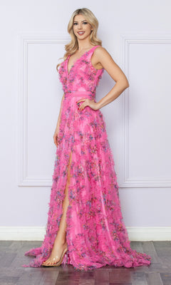 A woman poses indoors against a pale, decorated wall, wearing the Nox Anabel E1445—a pastel print, floor-length prom dress with floral details, a high slit, and sleeveless design.
