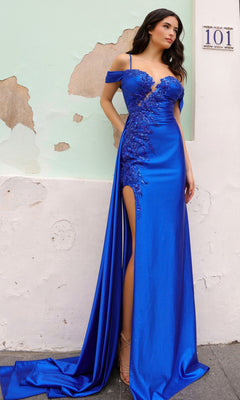 A woman poses against a weathered pale green wall under house number "101," wearing the Cold-Shoulder Long Corset-Back Prom Dress E1451 in vibrant blue, featuring floral appliqué and a thigh-high slit.