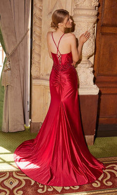 A woman wearing the Nox Anabel E1488 long corset prom dress with a train stands facing an ornate column.