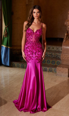 A woman stands indoors on marble flooring wearing the Nox Anabel E1532, a fitted, floor-length magenta mermaid prom dress with floral embellishments and beaded embroidery on the bodice.