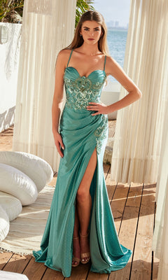 A woman stands on a wooden deck by the sea, wearing the Nox Anabel E1534 Lace-Up Corset Long Prom Dress in teal, featuring thin straps, floral embellishments, and a high leg slit.