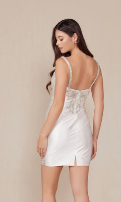 A woman models the Silver-Beaded Short White Homecoming Dress E912W, featuring embroidered straps and silver beading, against a plain light background.