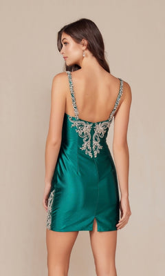 A woman models the Embellished Short Homecoming Dress E912, featuring green satin fabric, silver embroidery, an open back, and shoulder straps, against a plain beige background.