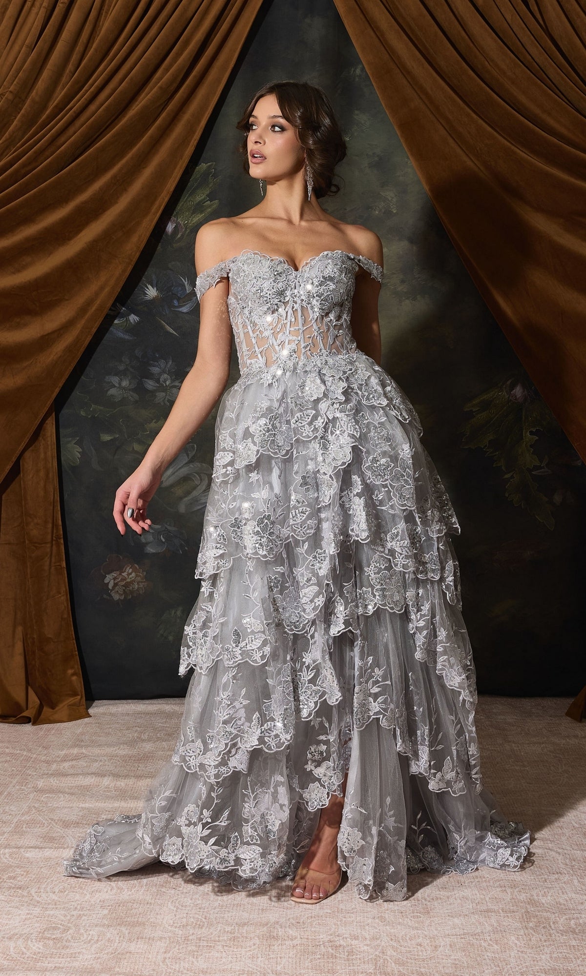Eureka EK102 off-shoulder, floor-length silver gown with an illusion bodice and a tiered, embroidered A-line formal skirt.