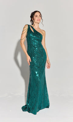 A woman wears the Eureka EK113 One-Shoulder Long Sequin Prom Dress in emerald green with beaded shoulder accents, posing against a plain light gray background.