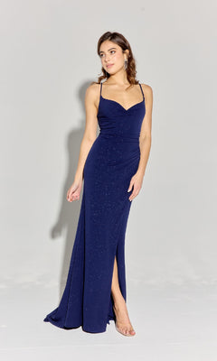 A woman wears the Spaghetti-Strap Glitter Prom Gown: Eureka EK116—a sleeveless, dark blue evening dress with thin straps, open back, thigh-high slit, and subtle glittery details.