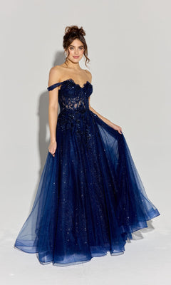 A woman in the Off-Shoulder Long Prom Ball Gown: Eureka EK128, featuring a corset-style bodice and navy blue sequined lace tulle skirt, stands against a plain light background.