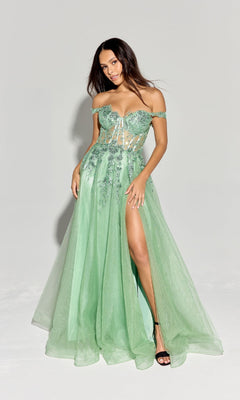 A woman wears the Off-Shoulder Long Prom Ball Gown: Eureka EK128, a light green dress with a corset-style bodice, floral embellishments, and a lace tulle skirt featuring a high slit, standing against a plain light background.