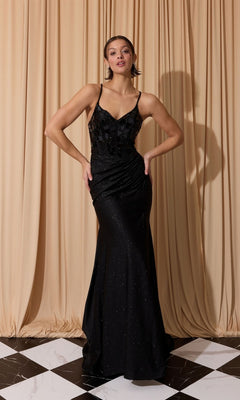 A woman stands on a black-and-white tiled floor before beige draped curtains, wearing the Eureka EK135 long prom dress in black featuring a fitted, sleeveless design with thin straps and a sequin bodice.