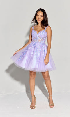 A woman wears the Eureka EK152 short fit-and-flare lace Hoco dress in light purple with floral embroidery, paired with beige high-heeled sandals. She smiles at the camera while holding the skirt against a plain background.